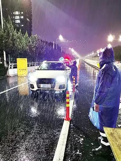 凌晨,东瓯大桥卡点处,永嘉县党员干部顶风冒雨、在严寒中牢牢值守。( 图片由浙江省温州市委组织部提供)